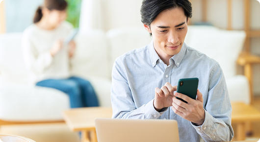 スマートフォンで申込みをする男性